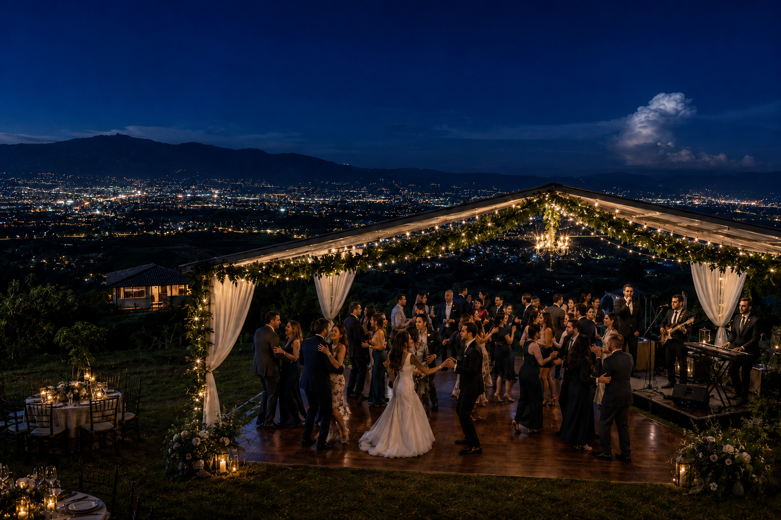 A night wedding reception under string lights at El Cerro, with the city lights of the Central Valley beyond